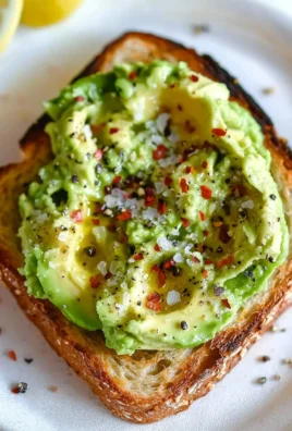 Delicious avocado toast topped with tomatoes and sesame seeds on a wooden table