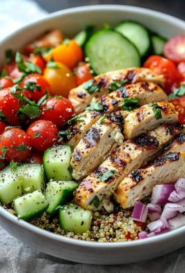 Delicious Greek Chicken Quinoa Bowl topped with fresh vegetables and herbs