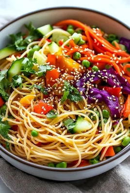 Colorful Sesame Noodle Salad garnished with fresh vegetables and sesame seeds.
