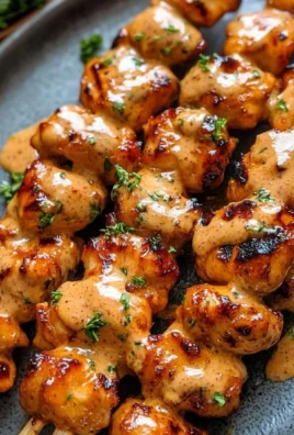 Delicious Bang Bang Chicken Skewers with a spicy sauce.