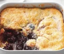 Deliciously baked blackberry cobbler topped with golden crust and fresh blackberries
