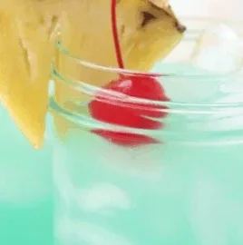 A vibrant Blue Hawaiian Mocktail served in a glass with tropical toppings.