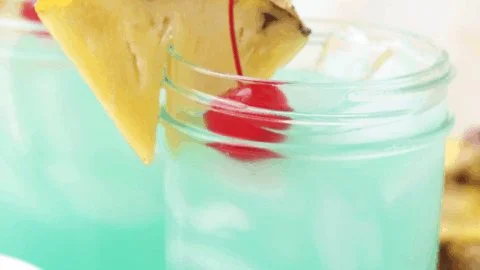 A vibrant Blue Hawaiian Mocktail served in a glass with tropical toppings.
