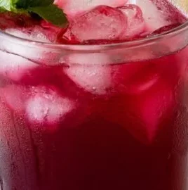 A refreshing glass of blueberry lemonade with fresh blueberries and lemon slices.