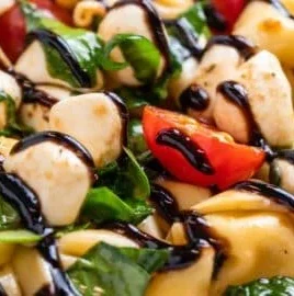 Caprese salad with tortellini, fresh tomatoes, mozzarella, basil and balsamic glaze