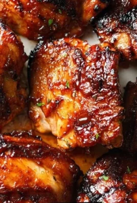 Oven-baked caramelized BBQ chicken thighs on a serving platter