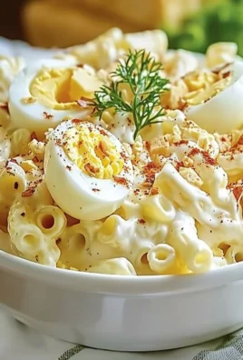 Bowl of classic deviled egg macaroni salad garnished with fresh herbs