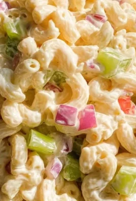 Bowl of classic macaroni salad with vegetables and dressing