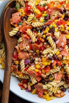 Colorful Cowboy Caviar Pasta Salad featuring fresh vegetables and beans