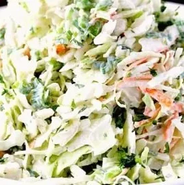 Creamy cilantro lime coleslaw served in a bowl with fresh ingredients.