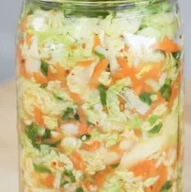 A jar of homemade kimchi showcasing vibrant colors and fresh ingredients