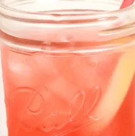 A refreshing homemade strawberry soda topped with fresh strawberries and ice.