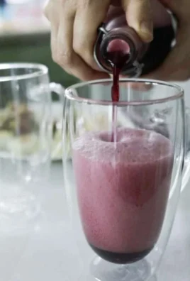 A refreshing glass of homemade whey soda with bubbles and lemon garnish.