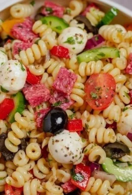 Colorful bowl of Italian pasta salad with fresh vegetables and herbs