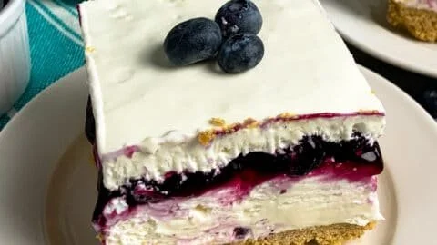 No-bake blueberry cheesecake bars topped with fresh blueberries