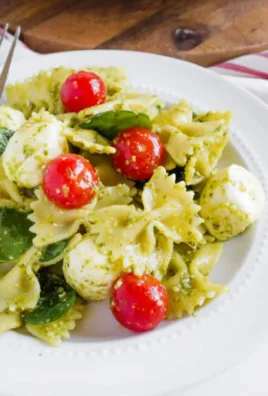 Bowl of colorful Pesto Caprese Pasta Salad with fresh ingredients