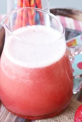 Probiotic Strawberry Soda in a glass with fresh strawberries on the side