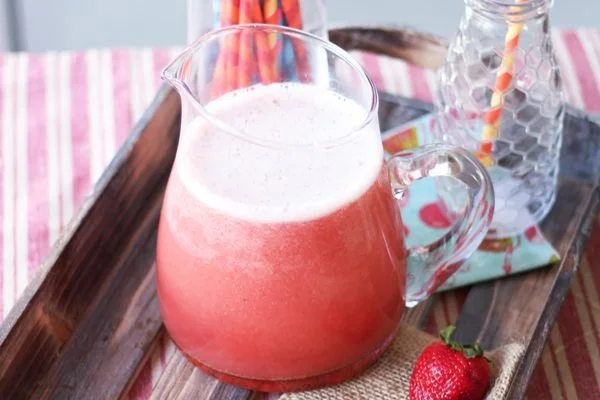 Probiotic Strawberry Soda in a glass with fresh strawberries on the side