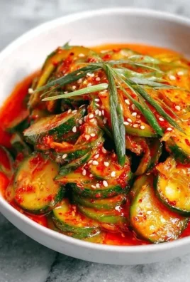 Quick Cucumber Kimchi in a bowl garnished with sesame seeds and green onions