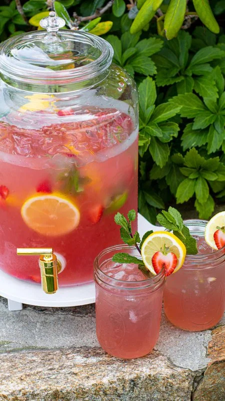 Sparkling lemonade punch served in a glass with ice and lemon slices.