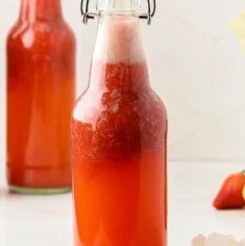 Refreshing strawberry kefir soda topped with fresh strawberries and mint