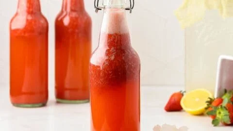 Refreshing strawberry kefir soda topped with fresh strawberries and mint