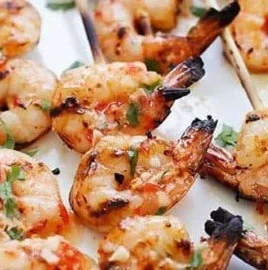 Sweet chili shrimp skewers on a grill, ready to serve.