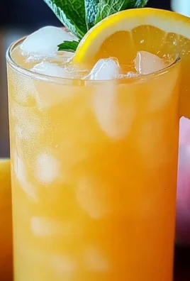 Sweet Tart Peach Lemonade in a glass with peach slices and lemons