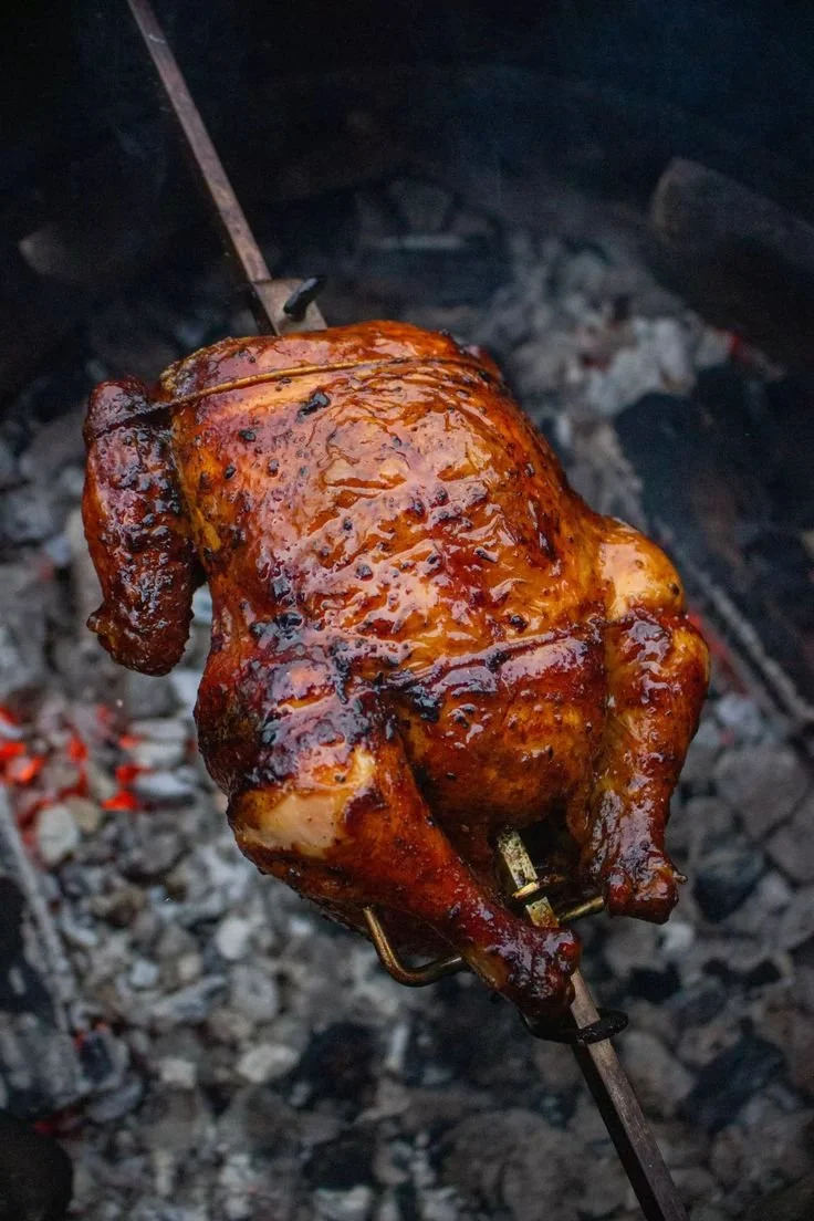 Delicious Tequila Lime Rotisserie Chicken garnished with lime and herbs.