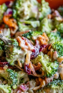 A vibrant bowl of the best broccoli salad with colorful vegetables and dressing.