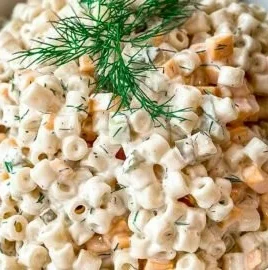 Creamy dill pickle pasta salad in a bowl with fresh dill garnish.