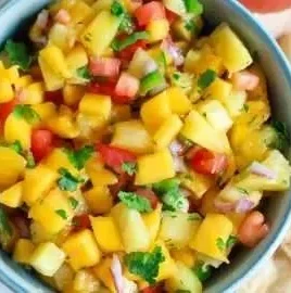 Fresh pineapple mango salsa served in a bowl with cilantro and lime
