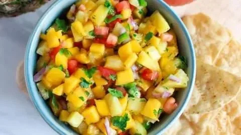 Fresh pineapple mango salsa served in a bowl with cilantro and lime