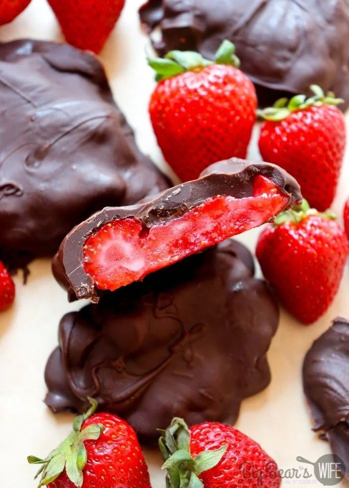 Frozen chocolate covered strawberry bites on a white plate