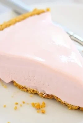 Delicious frozen pink lemonade pie garnished with lemon slices and mint.