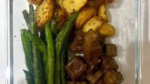 Garlic balsamic steak bites served on a plate with herbs