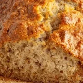 Slice of moist Greek yogurt banana bread on a wooden cutting board