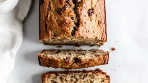 Slice of Greek yogurt banana bread with banana slices on a plate