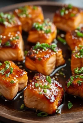 Honey garlic salmon bites served on a platter with garnishes.