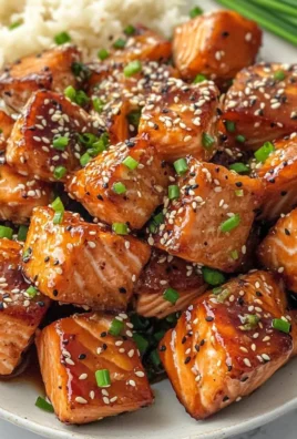 Honey garlic salmon bites served on a platter with garnish.