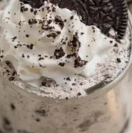 Oreo no-bake cheesecake cups topped with crushed Oreos and whipped cream