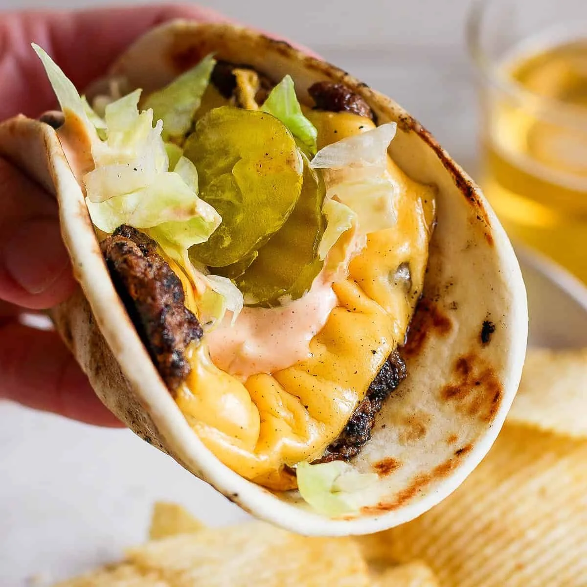 Delicious smash burger taco topped with homemade burger sauce.