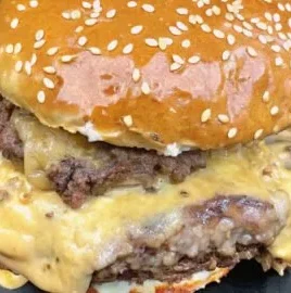 Juicy smash burgers topped with baconnaise served on a rustic wooden table