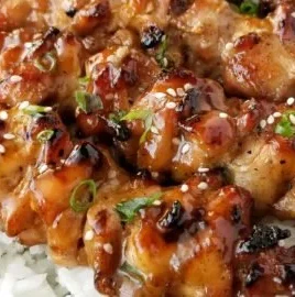 Grilled teriyaki chicken skewers on a serving plate with vegetables