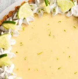 No-bake Vegan Key Lime Pie topped with lime slices and coconut cream.
