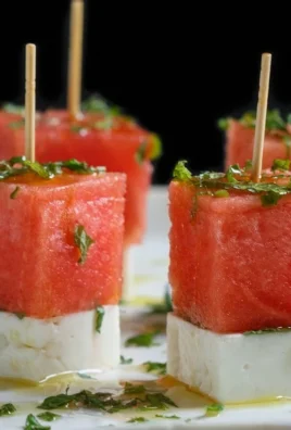 Watermelon skewers topped with feta cheese and mint leaves, ideal summer snack