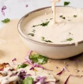 Baja Sauce drizzled over tacos for a zesty flavor