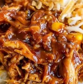 Delicious BBQ chicken rice bowl topped with fresh vegetables and sauces.