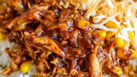 Delicious BBQ chicken rice bowl topped with fresh vegetables and sauces.
