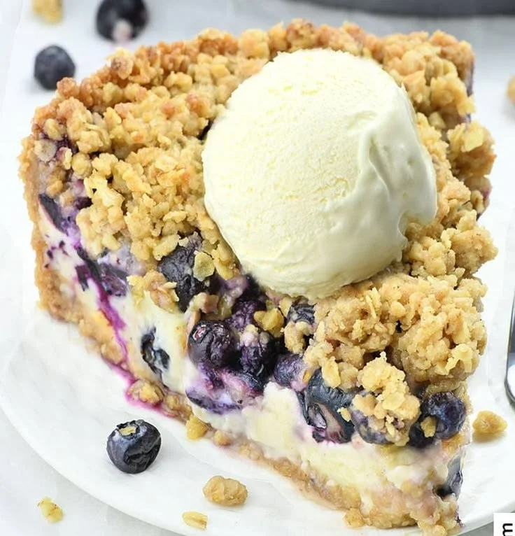 Delicious blueberry crumble cheesecake pie topped with juicy blueberries and crunchy crumble.